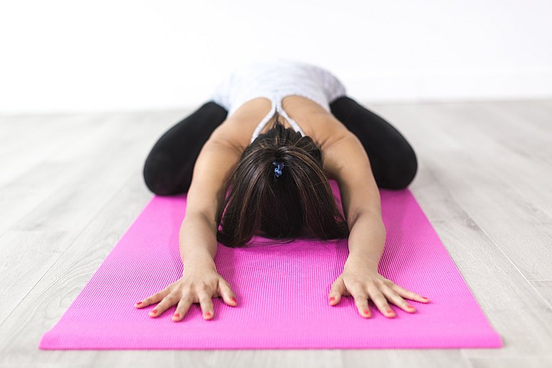 Frau macht Yoga - Stressabbau